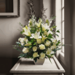 Arreglo de flores blancas con lirios y rosas en jarrón beige sobre una mesa clara, con fondo interior elegante y luz natural entrando por la ventana