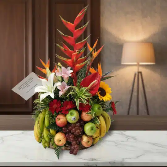 Arreglo floral premium 'Eclipse' con heliconias, lirios, girasoles y frutas frescas como manzanas, uvas y plátanos, sobre una