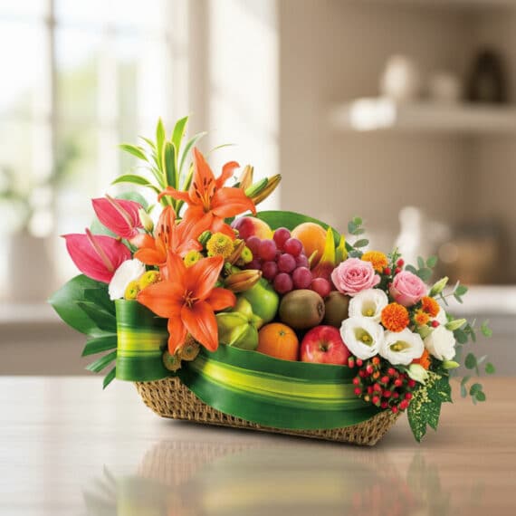 Elegante Cesta Frutal THALIA con Lirios y Anturios Frescos Cesta de frutas THALIA con lirios naranjas, anturios rosas, rosas, uvas, manzanas, kiwis y naranjas, sobre mesa de madera cla