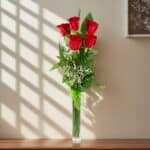 Arreglo floral Solitario con Rosas Marilyn en un jarrón de cristal, sobre una superficie de mármol pulido, con un fondo elega